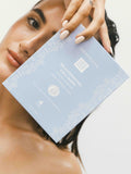 Woman holding a box of Dermalogica Rejuvenating Collagen masks against a neutral background