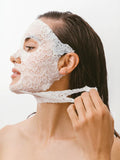 Woman wearing a Dermovia lace face mask against a white background