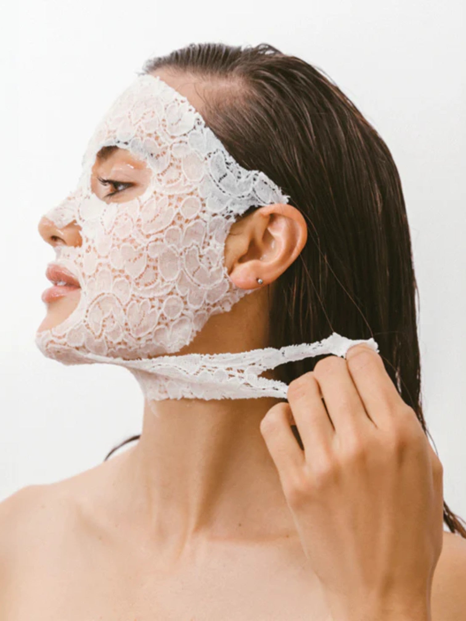 Woman wearing a Dermovia lace face mask against a white background